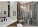 Stylish bathroom featuring a wood-look vanity, a glass enclosed shower and modern fixtures at 13176 Frannys Way, Parker, CO 80138