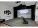 In-home golf simulator room with projector screen, equipment, and comfortable golf space at 13176 Frannys Way, Parker, CO 80138