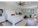 A bright main bedroom features hardwood floors, a ceiling fan, and large windows for lots of natural light at 13176 Frannys Way, Parker, CO 80138