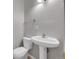A well lit half-bathroom with a modern pedestal sink and fixtures at 426 Kenton St, Aurora, CO 80010