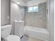 Bathroom with a sleek vanity, toilet, and a stylish shower-tub combination at 426 Kenton St, Aurora, CO 80010