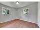 Bright bedroom with two windows, hardwood floors, and neutral gray walls at 426 Kenton St, Aurora, CO 80010
