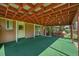 View of the covered patio with painted wood beams, brick exterior, and an easy access door at 426 Kenton St, Aurora, CO 80010