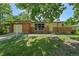 Charming brick home with large front windows and attached garage, shadowed by a large tree at 426 Kenton St, Aurora, CO 80010