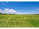 Expansive green field set against a clear blue sky with scattered clouds at 426 Kenton St, Aurora, CO 80010