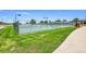 Multiple fenced tennis courts with lighting, next to sidewalks and a grassy park area at 426 Kenton St, Aurora, CO 80010