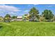 Community water park with colorful slides, grassy area and multiple trees on a sunny day at 426 Kenton St, Aurora, CO 80010