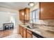 Galley style kitchen with granite countertops and wood cabinets at 7650 W 26Th Ave, Lakewood, CO 80214