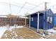 Backyard featuring a storage shed, gravel area, grass yard with partial snow coverage, and bare trees at 10799 Murray Dr, Northglenn, CO 80233