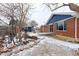 Brick home with a large yard, mature trees and partial snow coverage in the backyard at 10799 Murray Dr, Northglenn, CO 80233