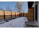 Snowy backyard with wood fence and raised garden beds at 3430 N Cook St, Denver, CO 80205