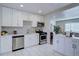 Open concept kitchen boasts white cabinets, stainless steel appliances, and an island at 3430 N Cook St, Denver, CO 80205