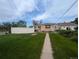 Manicured green backyard with walkway and partial view of home and fencing at 1009 Bush St, Brighton, CO 80601