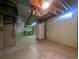 Unfinished basement with concrete floors, workbench, and white refrigerator at 1009 Bush St, Brighton, CO 80601