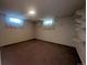 Unfinished basement space with two windows, neutral walls, and carpet flooring at 1009 Bush St, Brighton, CO 80601