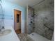 Updated bathroom with a walk-in shower featuring stylish gray tile and safety bars at 1009 Bush St, Brighton, CO 80601