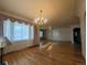 Bright living room with large windows, hardwood floors, and chandelier lighting at 1009 Bush St, Brighton, CO 80601