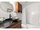Cozy bathroom includes a granite countertop, vanity with wood cabinets, modern sink, and tub at 14023 W Amherst Pl, Lakewood, CO 80228