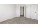 A bright bedroom features neutral carpeting, freshly painted walls, and a closet with sliding doors for optimal storage at 14023 W Amherst Pl, Lakewood, CO 80228