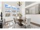 Elegant dining room with large windows, a modern chandelier, and a stylish wooden table at 14023 W Amherst Pl, Lakewood, CO 80228