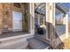 Charming front porch with blue-cushioned chair, stone accents, and a welcoming entrance at 14023 W Amherst Pl, Lakewood, CO 80228