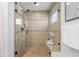 Modern shower features sleek glass doors, bench seating, and beautiful tile, with a window at 14023 W Amherst Pl, Lakewood, CO 80228