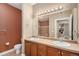 Bathroom with double sinks, dark wood cabinets, and large framed mirror at 9039 E Panorama Cir # C204, Englewood, CO 80112