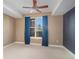A bedroom with neutral carpet, dark accent wall, ceiling fan, and lots of natural light at 9039 E Panorama Cir # C204, Englewood, CO 80112