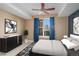 This bedroom features a ceiling fan, black dresser, and a window with blue curtains at 9039 E Panorama Cir # C204, Englewood, CO 80112