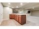 A wet bar with dark wood cabinets, granite countertops, and tile floors in the basement at 2344 S Lupine St, Denver, CO 80228