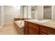 Luxurious bathroom featuring double sinks, a soaking tub, and granite countertops at 2344 S Lupine St, Denver, CO 80228