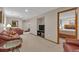 Spacious finished basement features a cozy seating area and access to another room with a queen sized bed at 7340 Brixham Cir, Castle Pines, CO 80108
