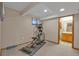 Basement fitness area with treadmill, weights and an adjacent bathroom at 7340 Brixham Cir, Castle Pines, CO 80108