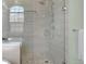 Walk-in shower featuring gray tiling, a decorative shower mosaic, and glass doors for a modern look at 7340 Brixham Cir, Castle Pines, CO 80108