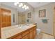 Bathroom with a large mirror, double sinks, and a tiled countertop and floors, with a separate toilet area at 7340 Brixham Cir, Castle Pines, CO 80108