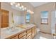 Bright bathroom features a double vanity with ample counter space, a large mirror, and tile flooring at 7340 Brixham Cir, Castle Pines, CO 80108