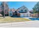 Charming two-story home boasts a 3-car garage, well-manicured lawn, and a classic brick and siding exterior at 7340 Brixham Cir, Castle Pines, CO 80108
