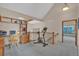 Second story loft area with wood railing, built-in bookcase, desk, chair, exercise bike, and stairway access at 7340 Brixham Cir, Castle Pines, CO 80108