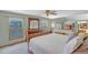 Bedroom with a large bed, wood dresser, windows, ceiling fan, and adjacent sleeping area on a second level at 7340 Brixham Cir, Castle Pines, CO 80108
