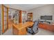 Bright office with a large desk, ample workspace, and adjacent view of the staircase at 7340 Brixham Cir, Castle Pines, CO 80108