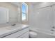 Bright bathroom featuring a white vanity, a mirror, a window and a tiled shower-tub combo at 10022 Wheeling St, Commerce City, CO 80022