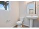 This well-lit bathroom features a pedestal sink, toilet, and window at 10022 Wheeling St, Commerce City, CO 80022