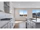 White kitchen with island, modern appliances, and large windows for ample natural light at 10022 Wheeling St, Commerce City, CO 80022
