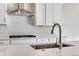 Close-up of a modern kitchen island with a sink, faucet, and a white countertop at 10022 Wheeling St, Commerce City, CO 80022