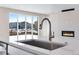 Modern kitchen island with white countertop and stainless steel faucet near a contemporary fireplace at 10022 Wheeling St, Commerce City, CO 80022
