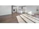 Sun-drenched open floor plan featuring light hardwood floors and a modern white kitchen at 10022 Wheeling St, Commerce City, CO 80022