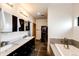 Bright Primary bathroom with double vanity, a soaking tub and modern lighting fixtures at 43010 Ptarmigan Ranch St, Parker, CO 80138