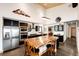 Modern kitchen boasting a large island with seating, high ceilings, black cabinets, and stainless appliances at 43010 Ptarmigan Ranch St, Parker, CO 80138