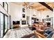 Bright living area featuring high ceilings, wood beams, a fireplace, and open layout to the kitchen at 43010 Ptarmigan Ranch St, Parker, CO 80138
