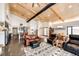 Open-concept living space with wood beams, an adjacent dining area, and seamless access to the kitchen at 43010 Ptarmigan Ranch St, Parker, CO 80138